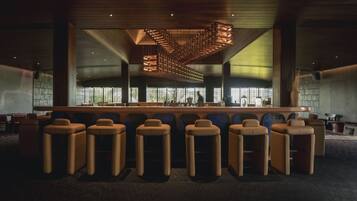 A bar area with high stools and a wooden ceiling design.