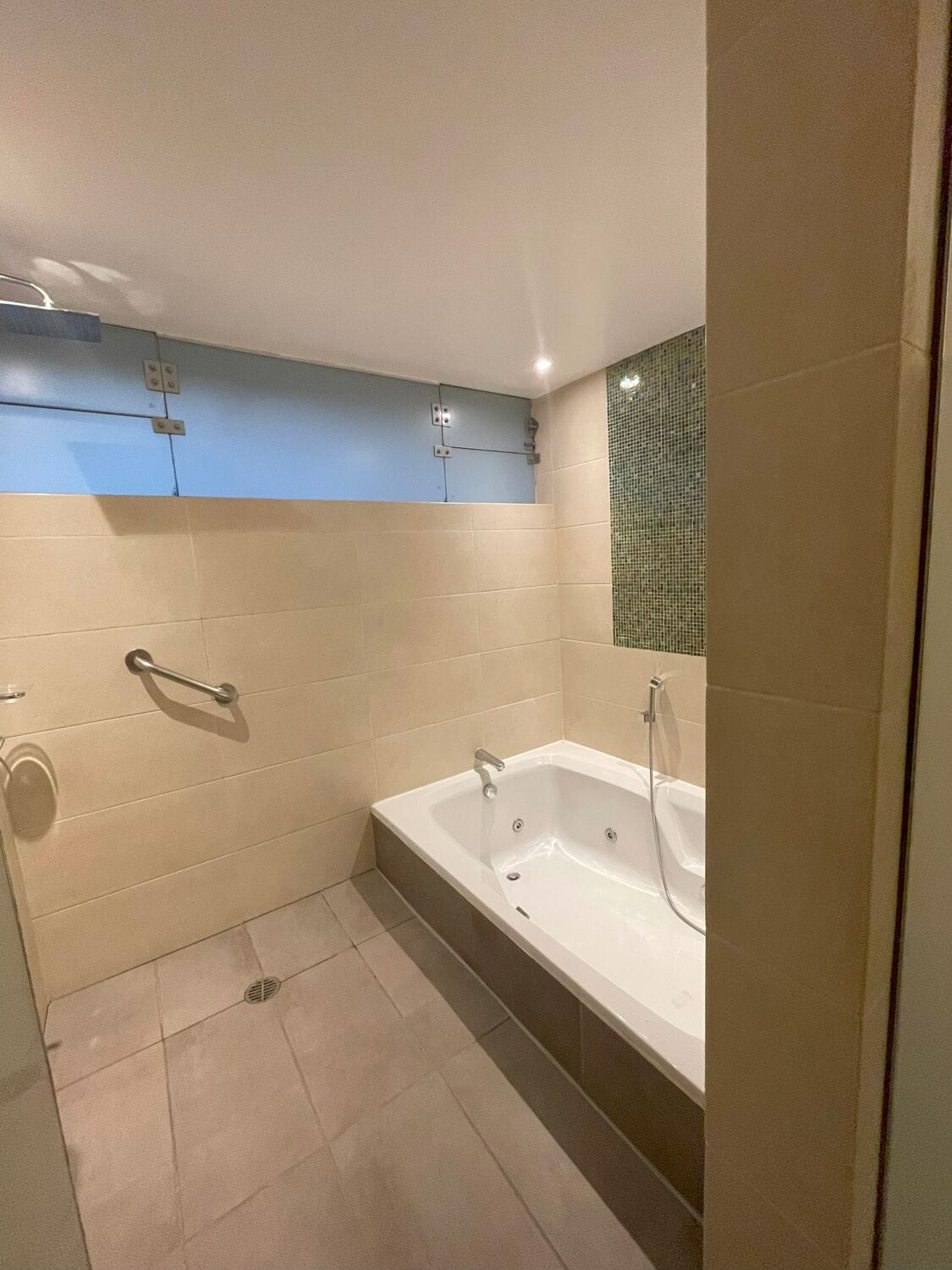 A modern bathroom with a bathtub, a shower, and a toilet.