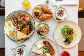 Una mesa con una variedad de alimentos y bebidas para el desayuno.