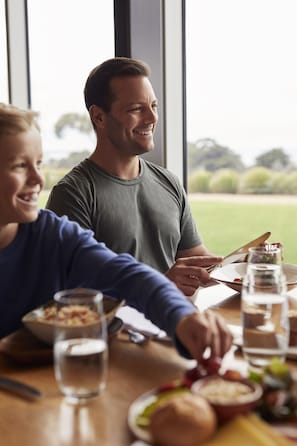 A dining table with a meal, a glass of water, and a bottle of water.