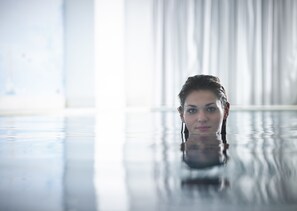 Una piscina al aire libre de temporada, sombrillas, tumbonas