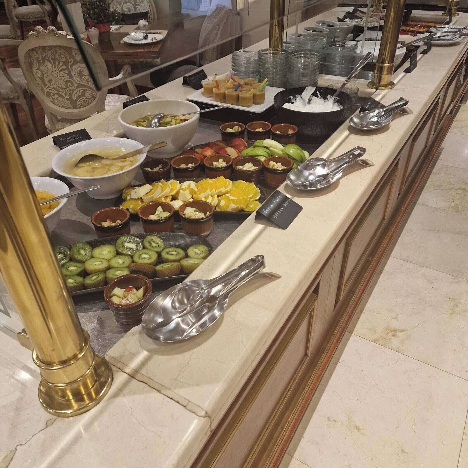 Un buffet proposant une variété de plats et d’ustensiles de service.
