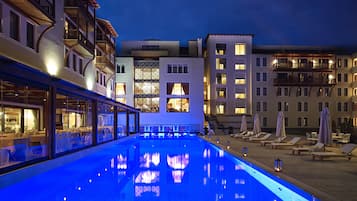 Una piscina techada, una piscina al aire libre de temporada, sombrillas
