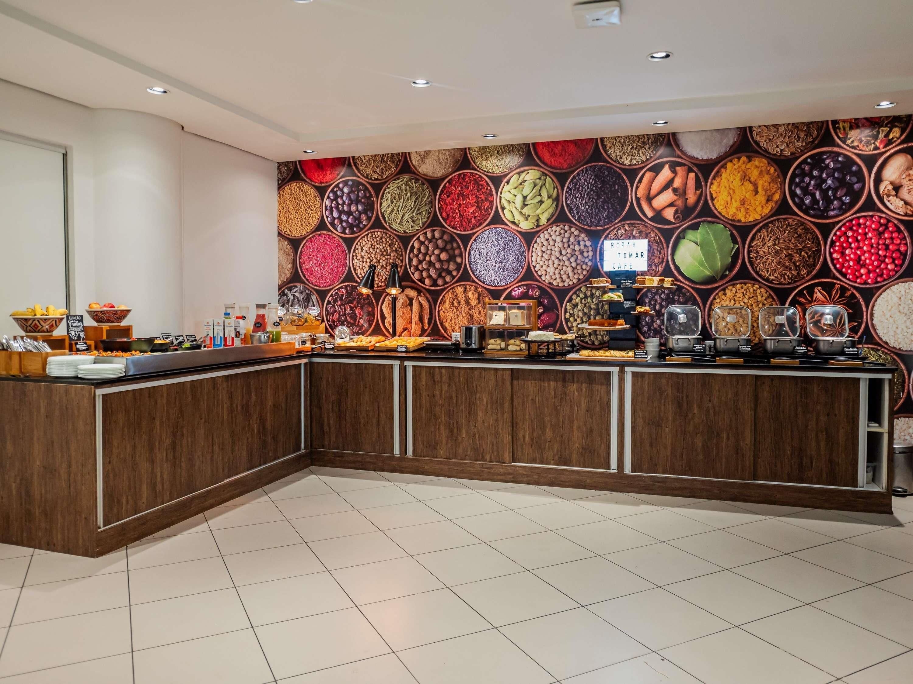 A buffet area with a variety of food items and a wall decorated with spices.