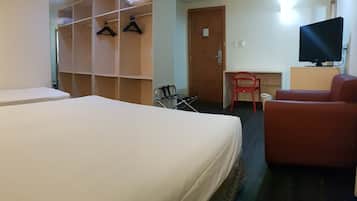 Una habitación de hotel con dos camas, un escritorio, una silla y un televisor.