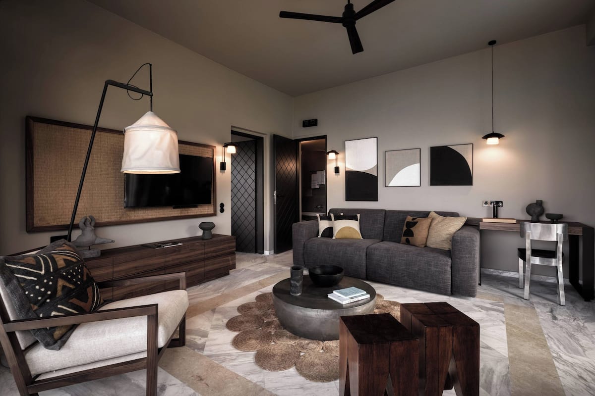 A modern living room with a sofa, coffee table, and a TV mounted on the wall.