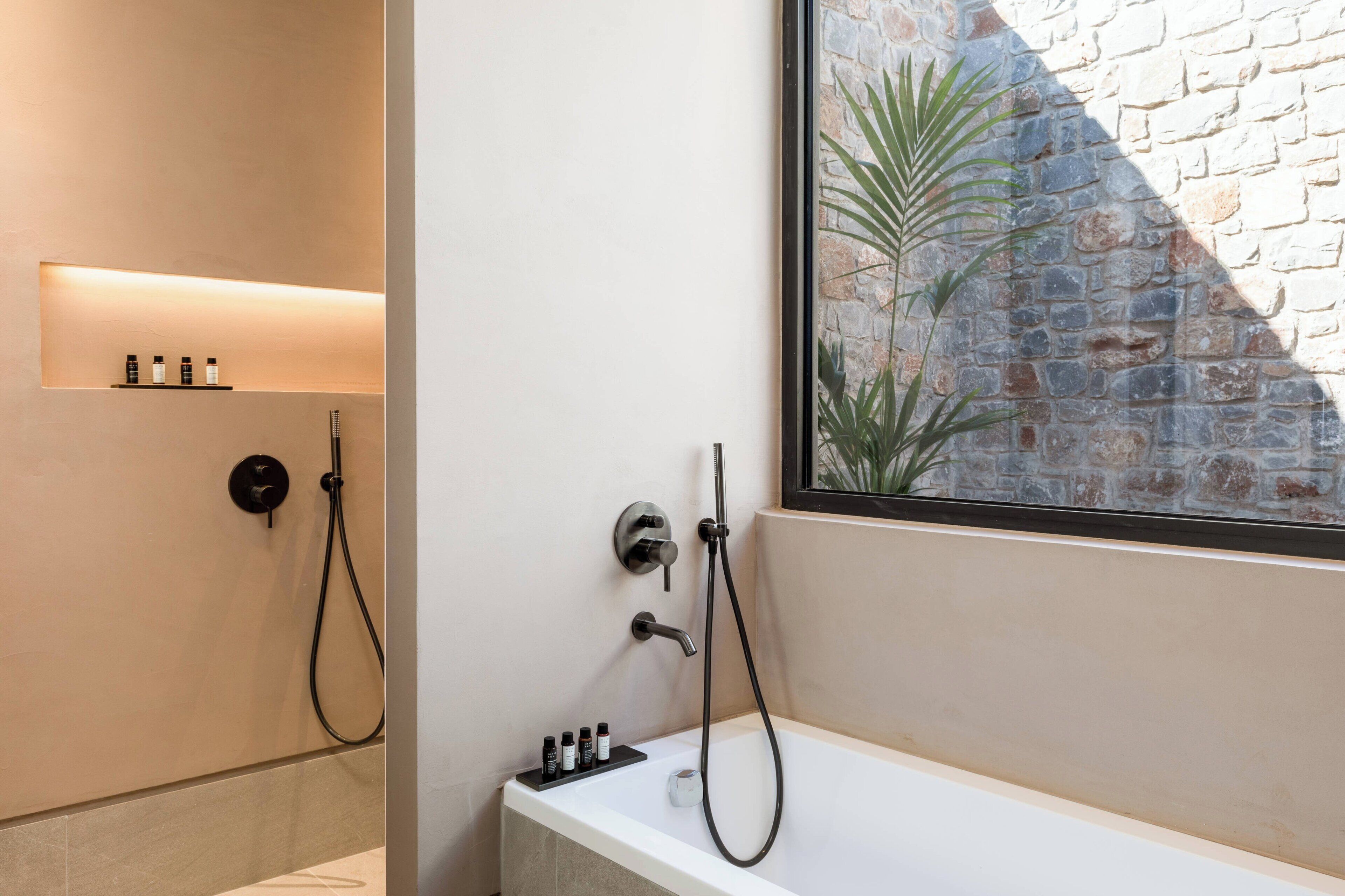 A modern bathroom with a shower, a bathtub, and a shelf with toiletries.