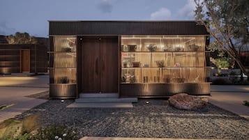 Un edificio moderno con puerta de madera y listones verticales a los lados.