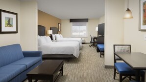 A hotel room with a blue sofa, two single beds, a desk with a chair, and a TV. - Holiday Inn Express Hotel & Suites Uvalde by IHG (Uvalde)