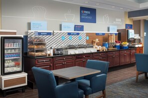 A breakfast area with a self-serve station, seating, and a refrigerator with dairy products. - Holiday Inn Express Hotel & Suites Uvalde by IHG (Uvalde)
