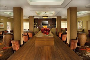 A conference room with a long table, chairs, a television, and a large window.