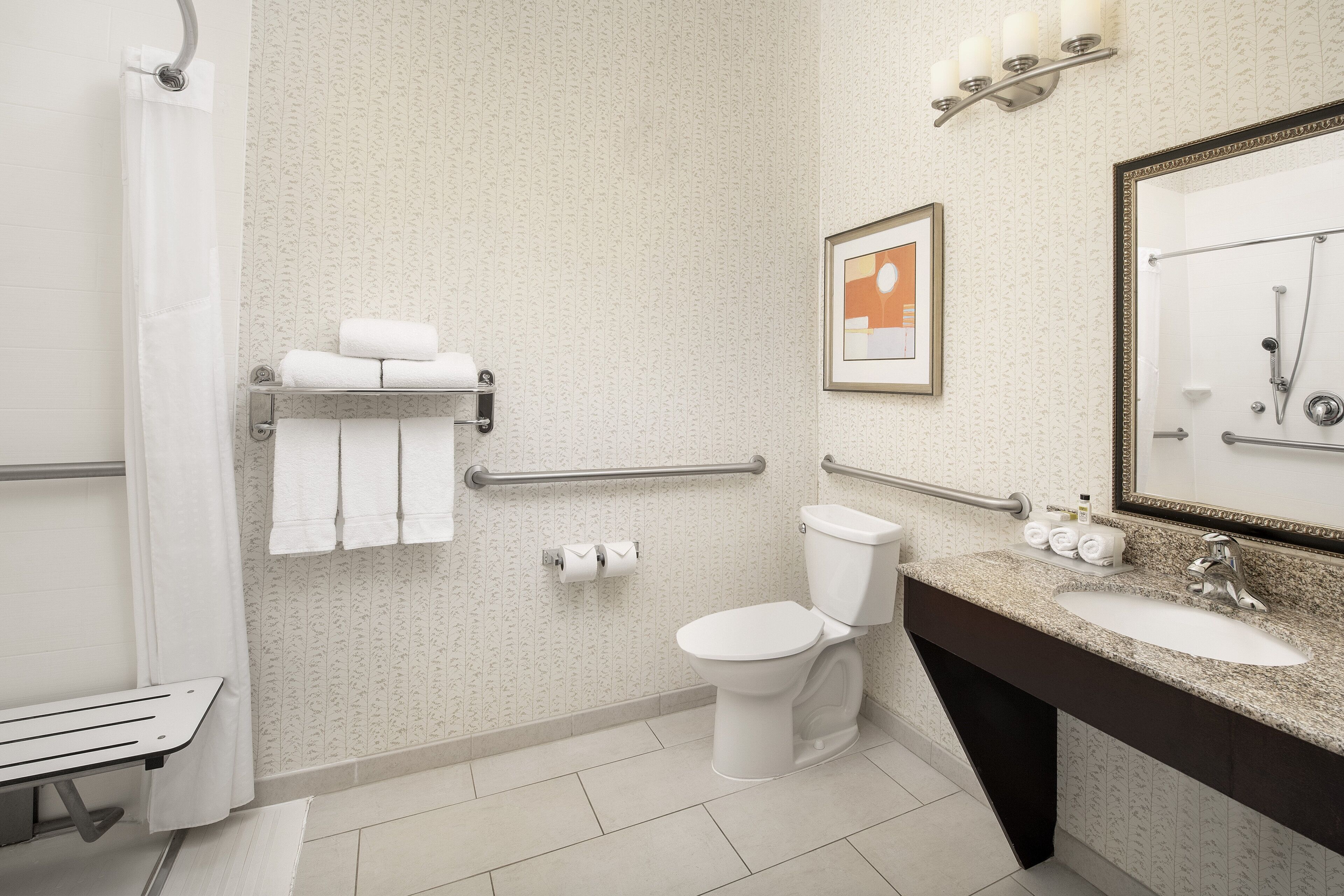 A modern bathroom with a toilet, sink, and shower.
