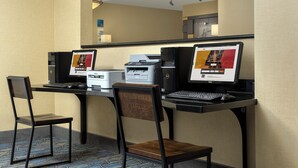 A hotel room with a desk, two chairs, a desktop computer, a printer, and a laptop. - Holiday Inn Express Hotel & Suites Uvalde by IHG (Uvalde)