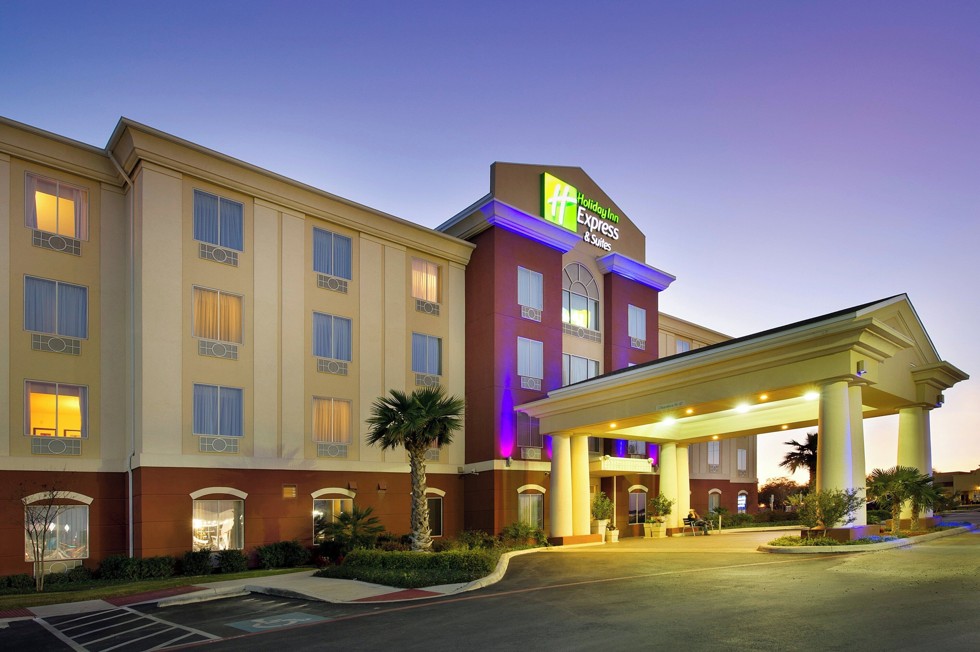 A Holiday Inn Express & Suites hotel with a covered entrance and a parking lot.
