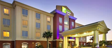 A Holiday Inn Express & Suites hotel with a covered entrance and a parking lot.