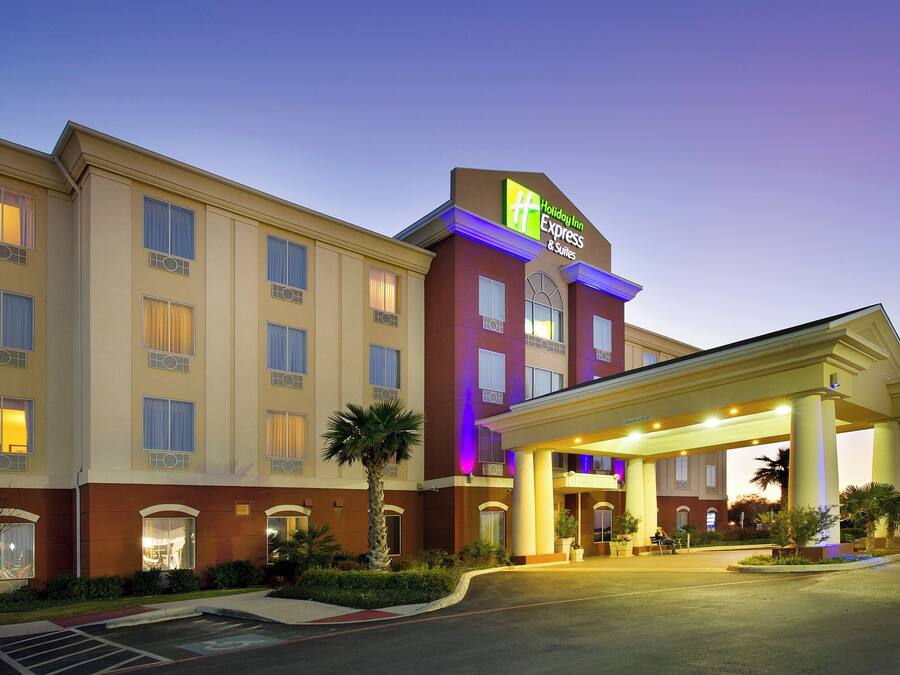 A Holiday Inn Express & Suites hotel with a covered entrance and a parking lot.
