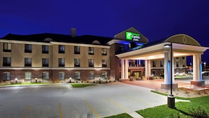 A Holiday Inn Express & Suites building at night with a well-lit entrance and a parking lot. - Holiday Inn Express Hotel & Suites East Lansing by IHG (East Lansing)
