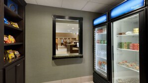 A hotel lobby with a snack bar, a mirror, and a refrigerated display case. - Hampton Inn & Suites Birmingham East Irondale (Birmingham)