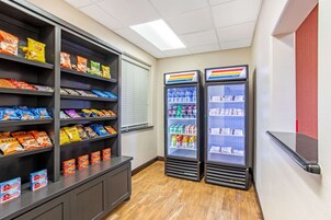 A snack and beverage area with shelves stocked with various snacks and two refrigerated beverage dispensers.