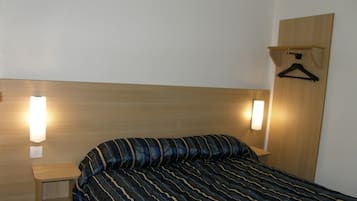 Cozy retreat with a single bed, two bedside tables, and a wardrobe for a comfortable stay.