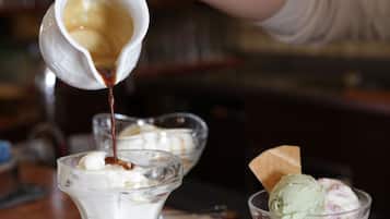 Ein Dessert wird zubereitet, eine cremige Soße wird darüber gegossen.