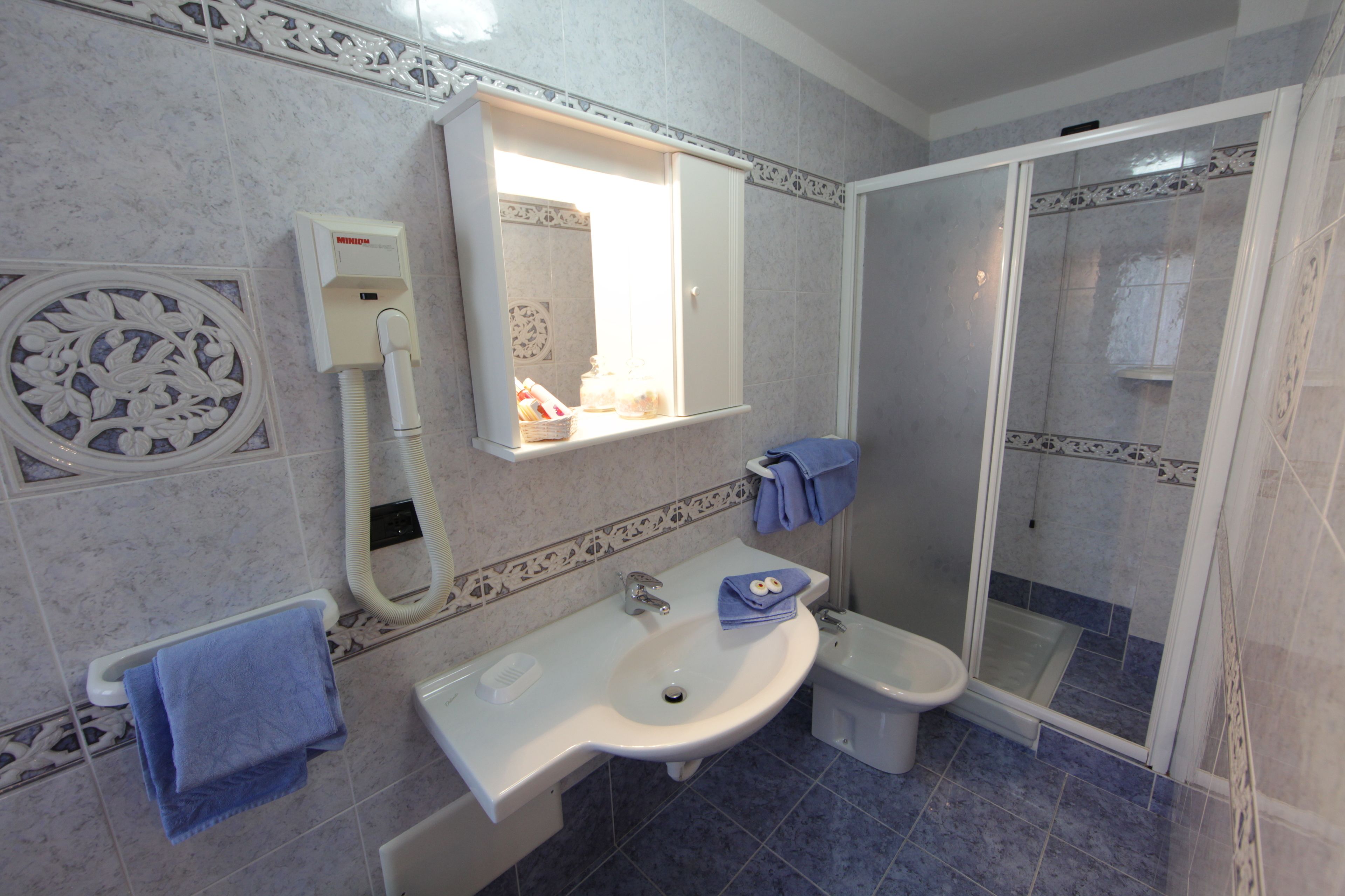 Un bagno con lavandino, WC e doccia.