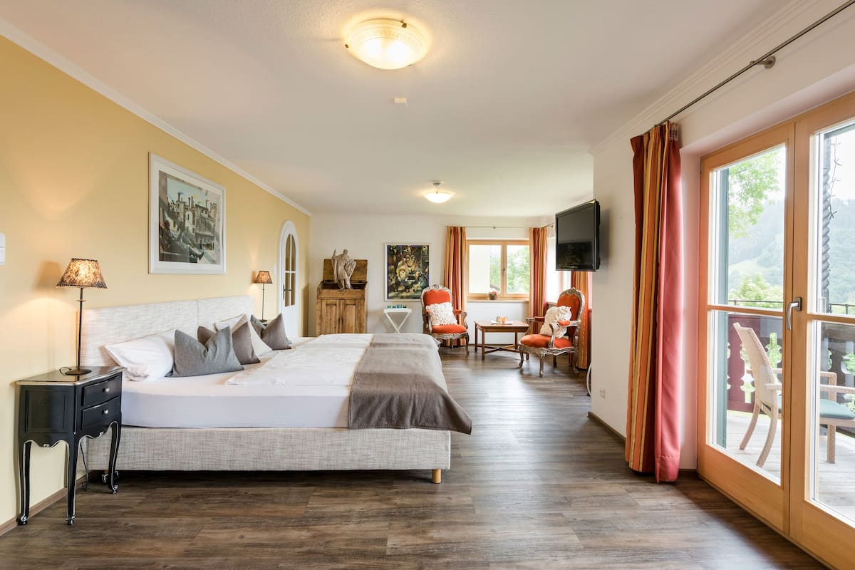 Une chambre spacieuse avec un grand lit, un bureau et une télévision.