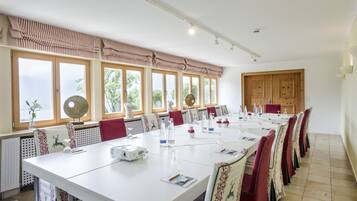 Une salle de conférence équipée d’une longue table, de chaises et d’un projecteur.