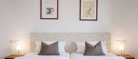 Una cama doble con dos mesitas de noche, cada una con una lámpara, en una habitación de hotel.