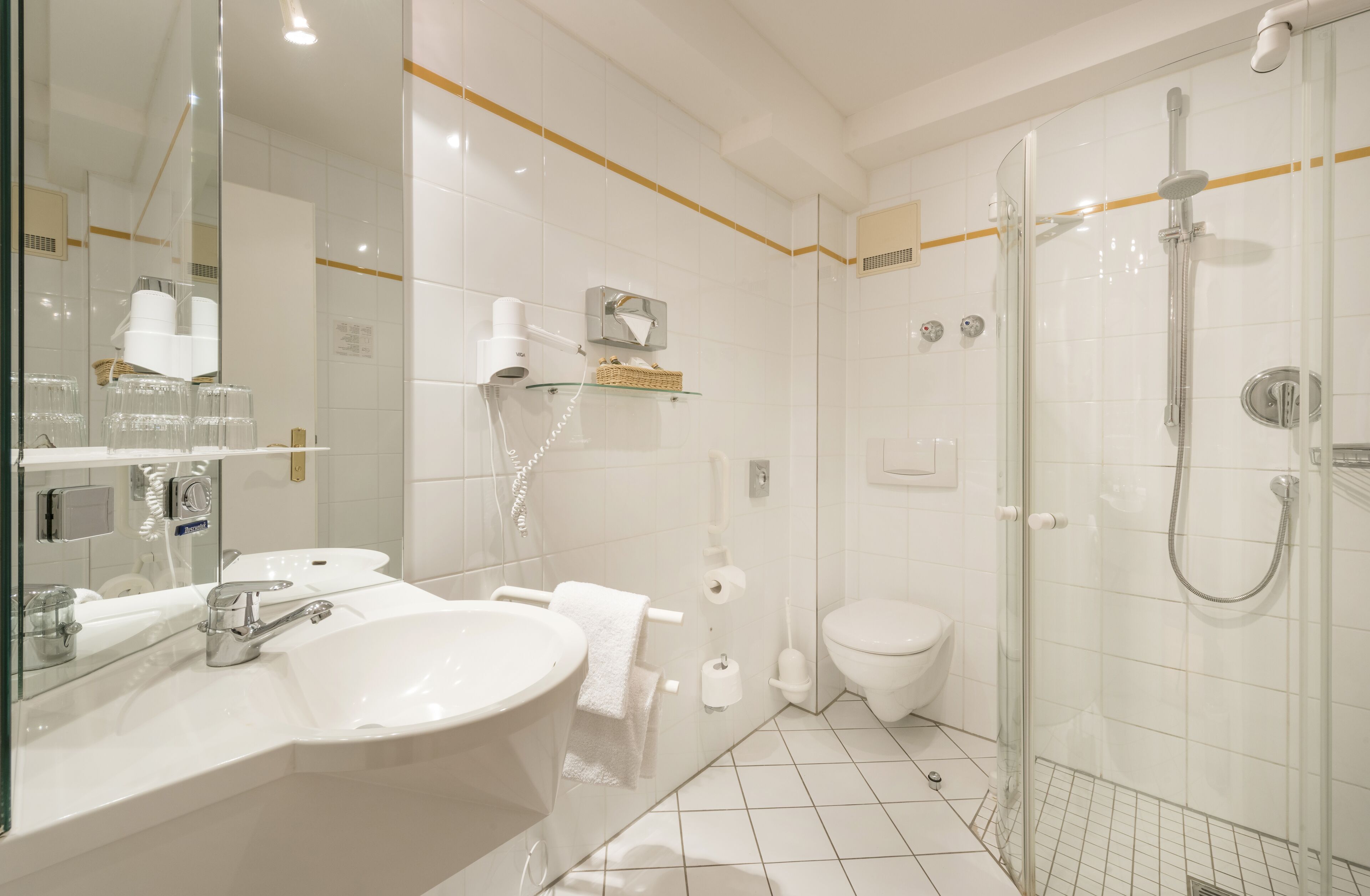 A modern bathroom with a large sink, a toilet, and a glass-enclosed shower area.