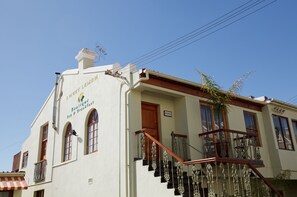 A building with a sign reading "Boutique Bed & Breakfast" and "Sweet Lemon." It features a staircase with ornate railings and a wooden door.