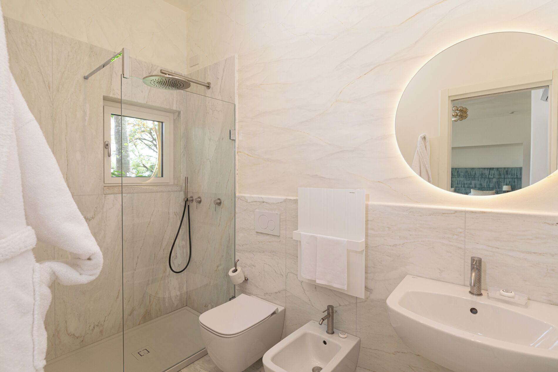 A modern bathroom with a shower, toilet, bidet, and sink.