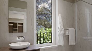 Un bagno moderno con un'ampia finestra, un lavandino, uno specchio e uno spazio doccia.