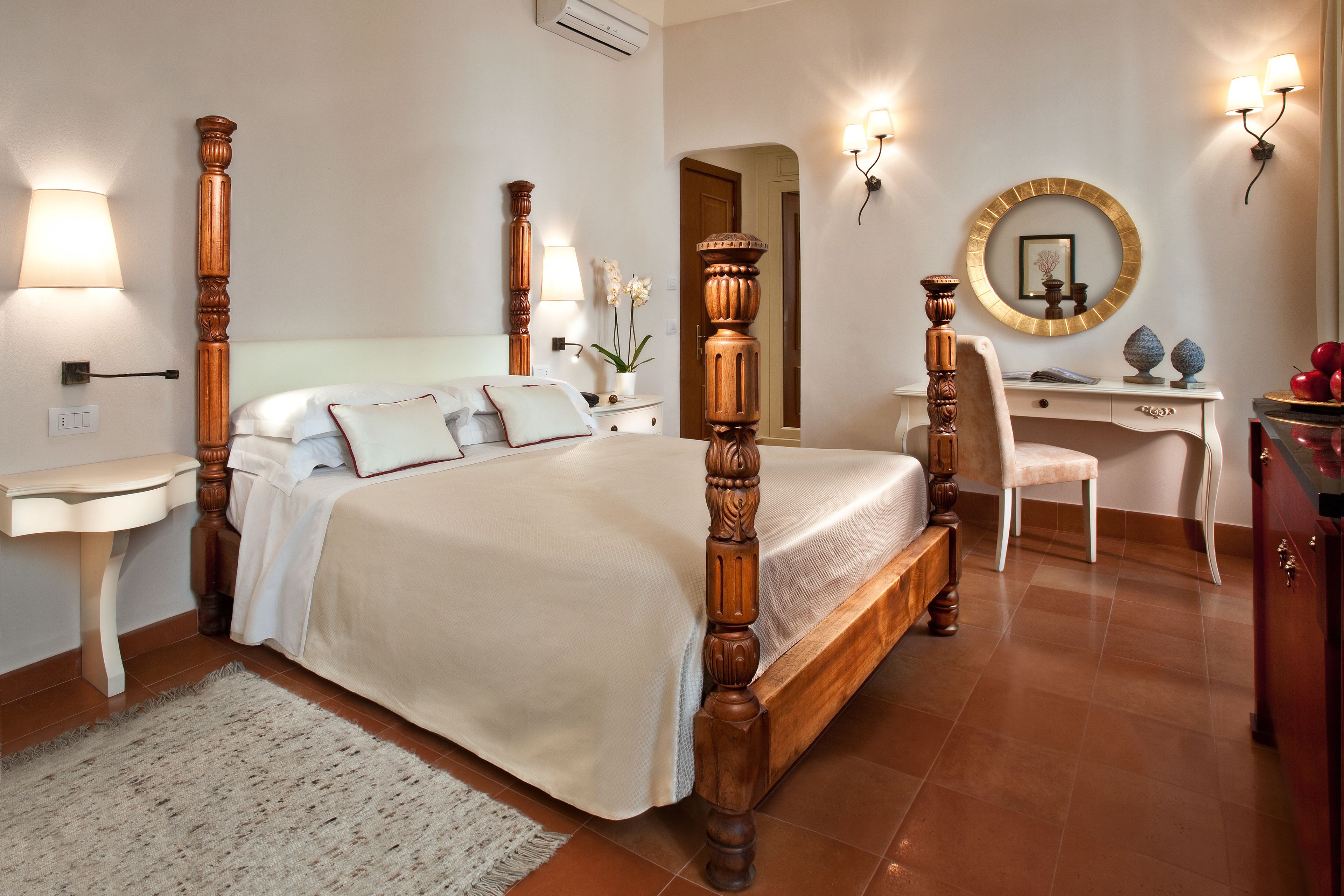 A bedroom with a four-poster bed, a desk, a chair, and a dresser.
