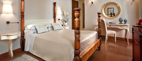 A bedroom with a four-poster bed, a desk, a chair, and a dresser.