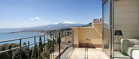 Un balcón con vistas despejadas a un pueblo costero y una montaña.