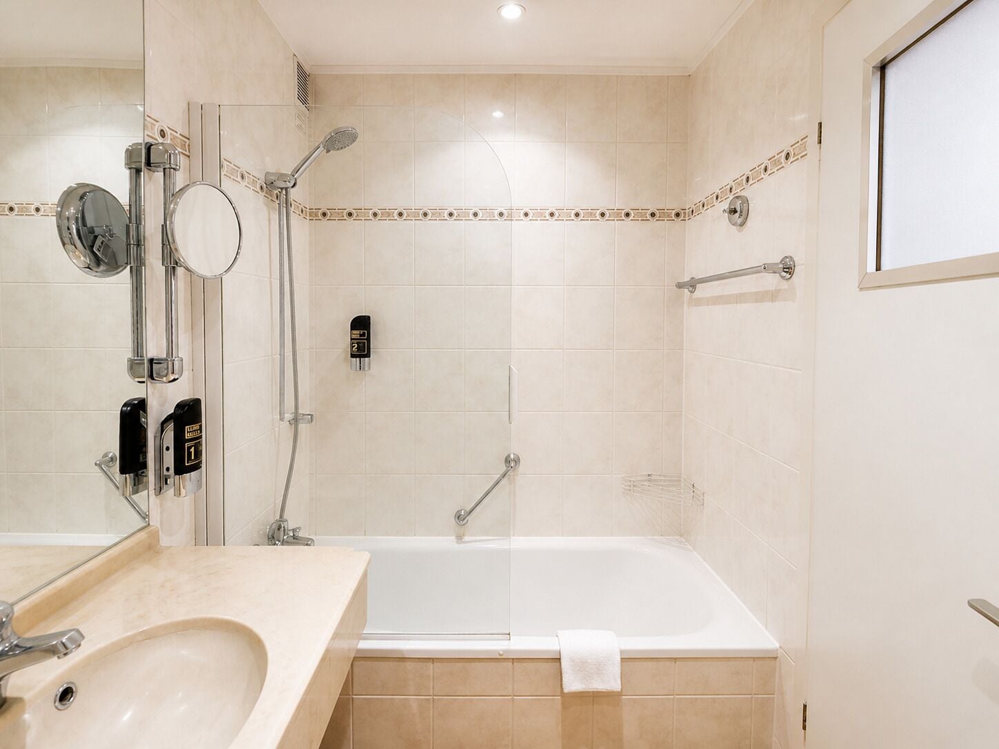 Ein Badezimmer mit Badewanne, Dusche, Waschbecken und Spiegel.