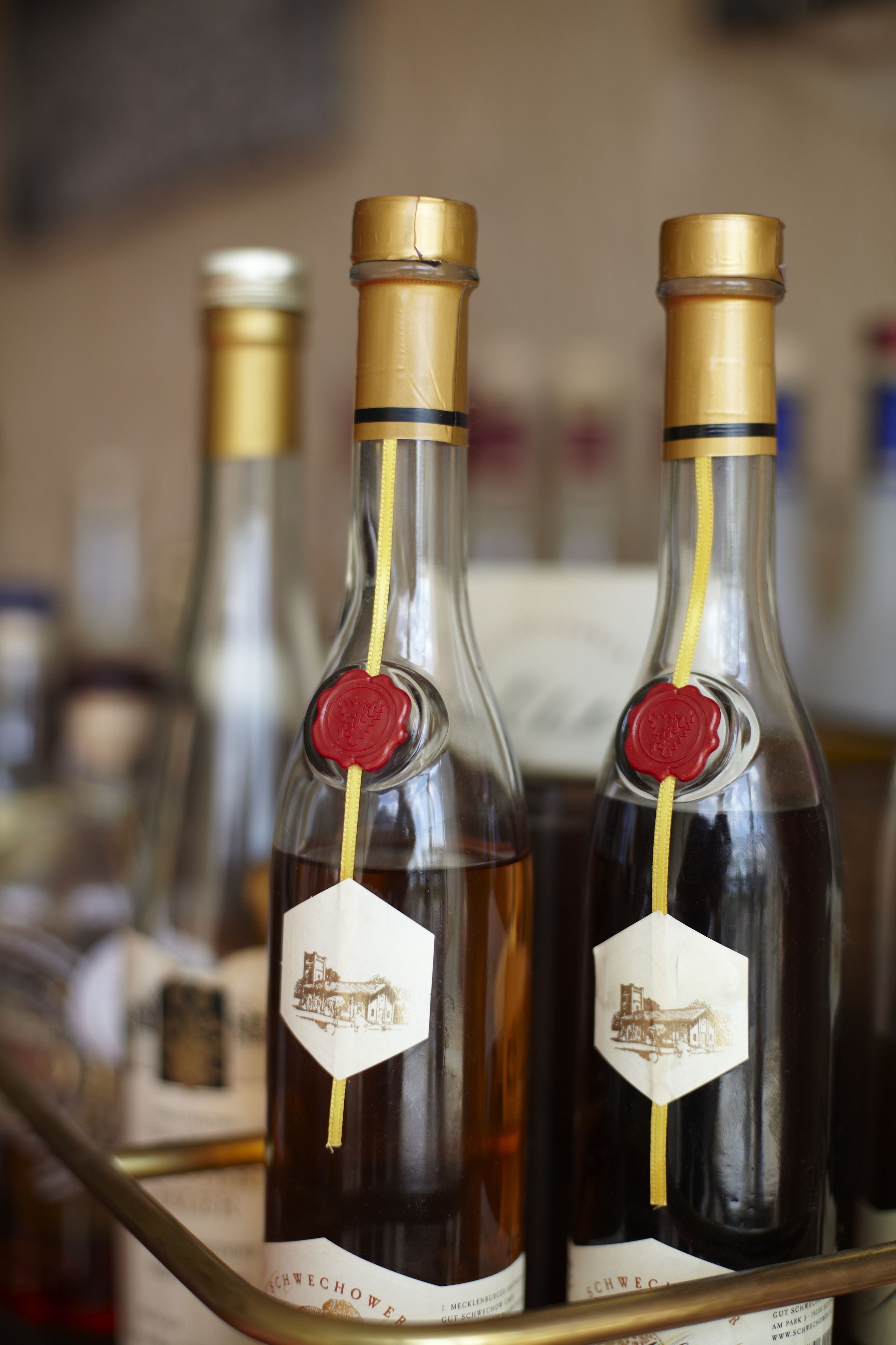 Duas garrafas de vinho com lacre de cera e etiquetas, apoiadas numa estrutura de metal.