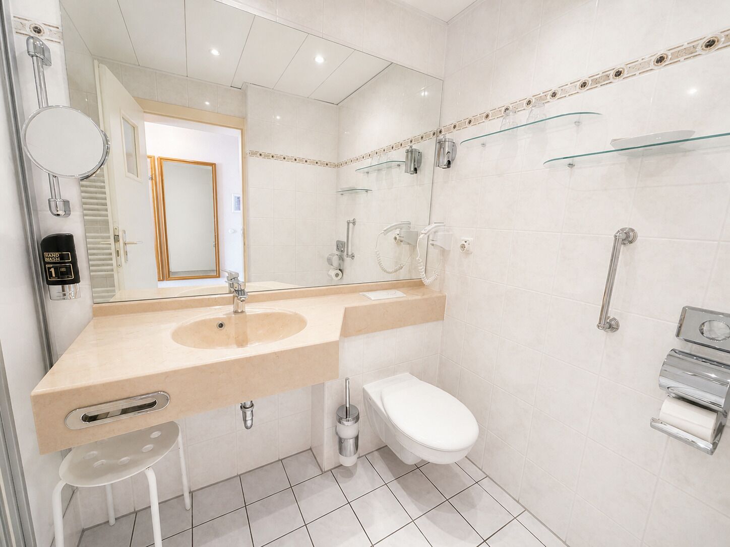Ein modernes Badezimmer mit Waschbecken, Spiegel, Toilette und Dusche.