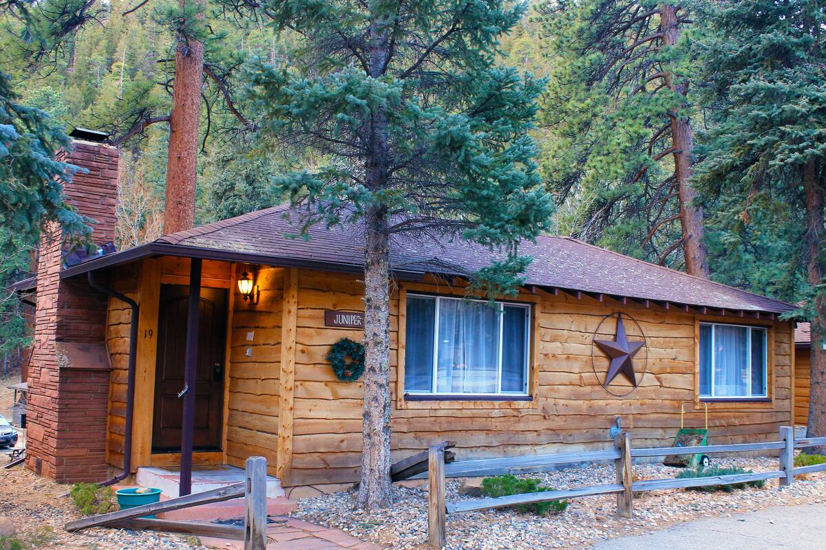 Une cabane en rondins avec une façade en bois, une porte d’entrée et une décoration en forme d’étoile sur le mur.