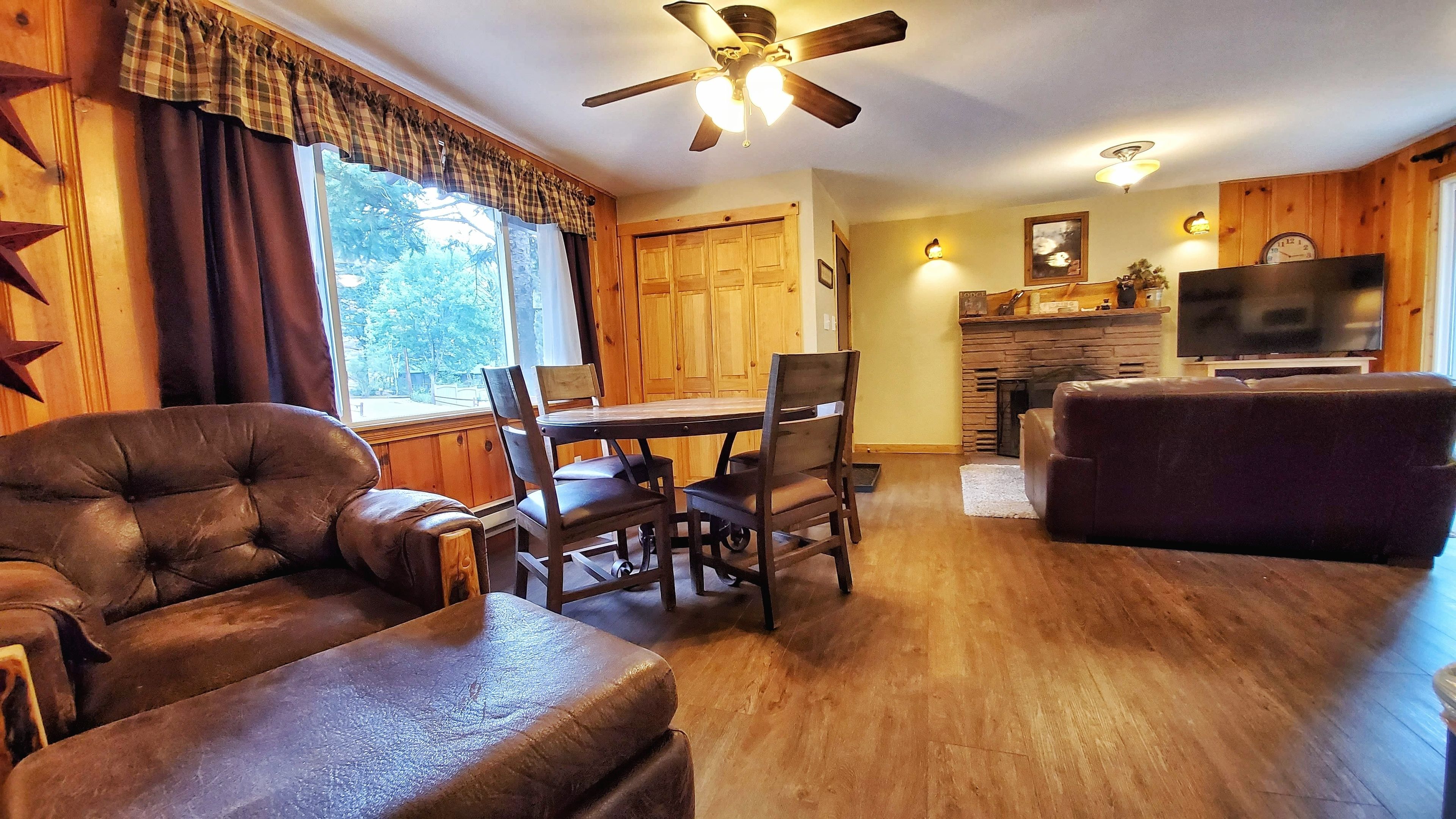 A cozy living room with a fireplace, a dining area, and a television.