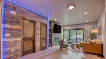 Ein modernes Interieur mit Holzvertäfelung, einem Flachbildfernseher, einer Sitzecke und einem Essbereich.