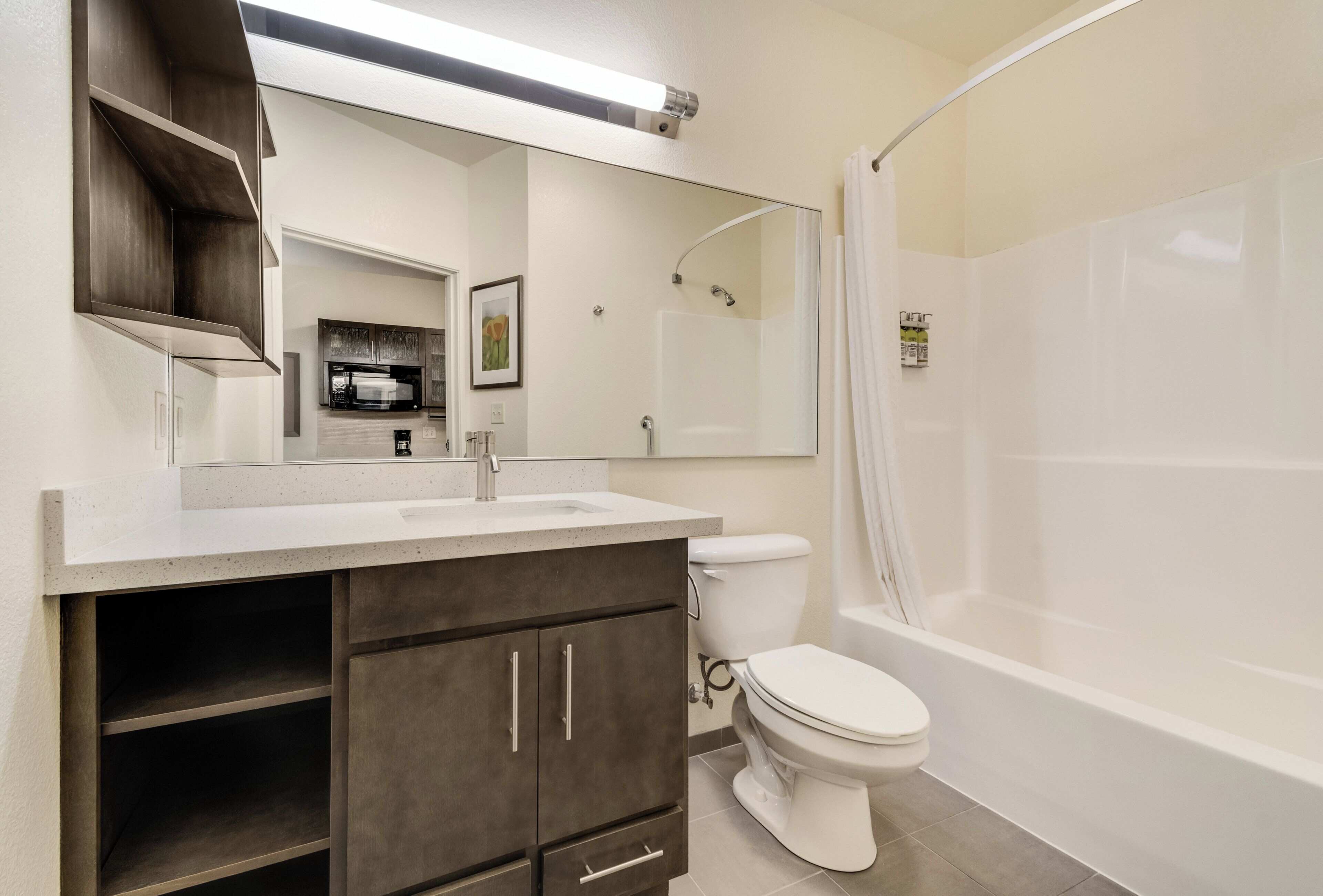 Un baño con un lavabo blanco, armarios oscuros, un inodoro y una bañera.