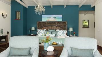 A bedroom with teal walls, a wooden headboard, a chandelier, and a large window.