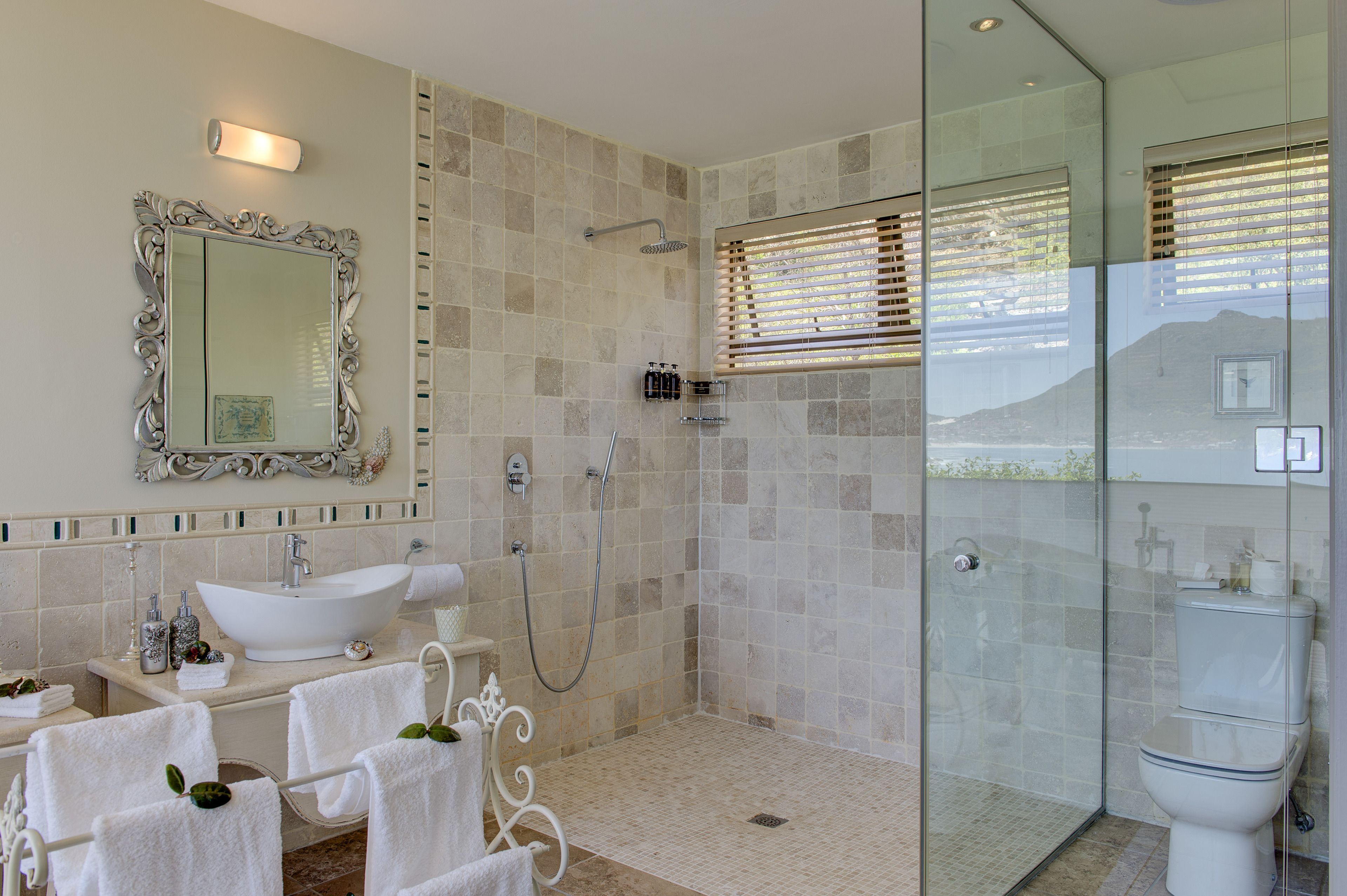 Ein Badezimmer mit großem Spiegel, Waschbecken, Dusche und Toilette.
