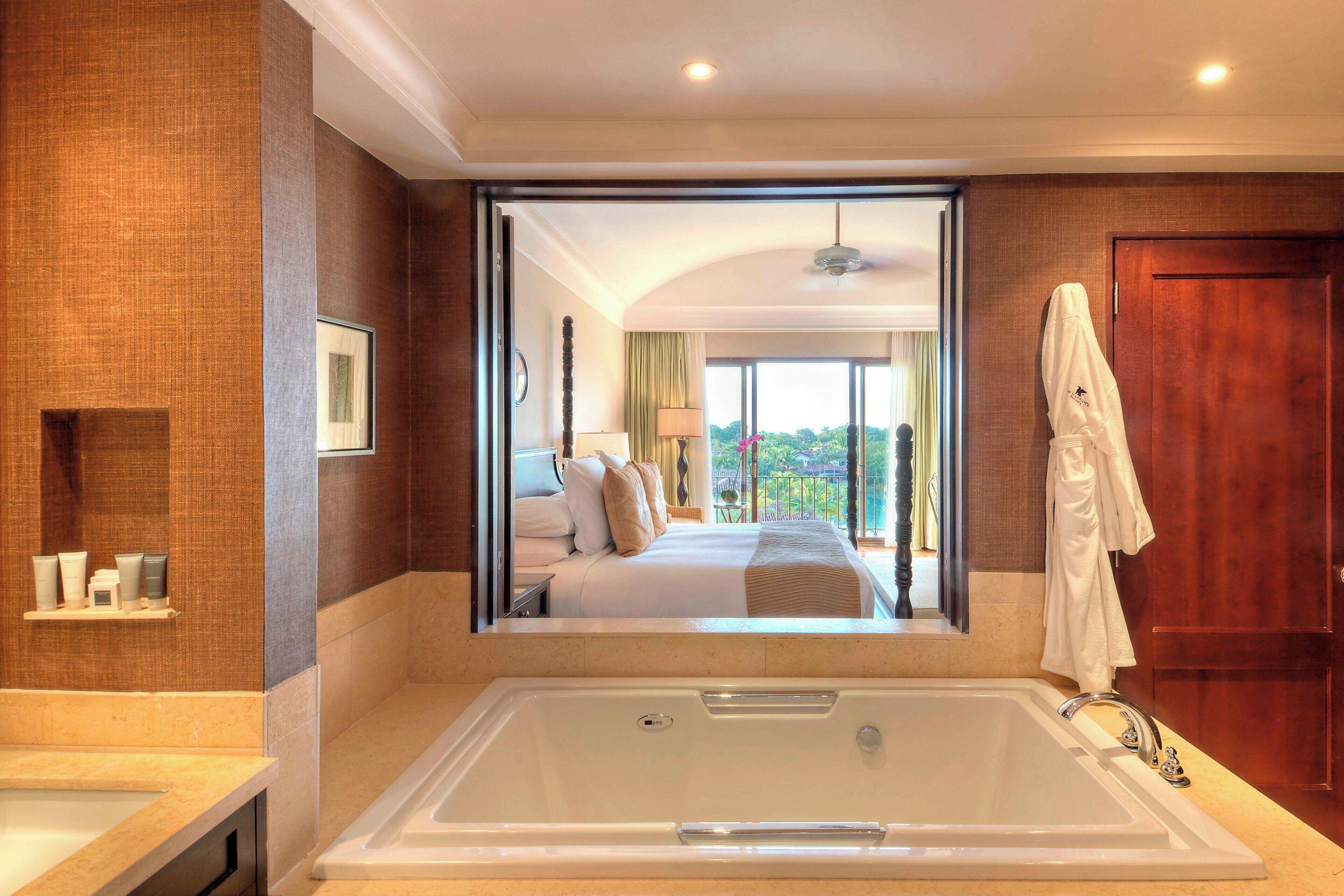 A modern bathroom with a large bathtub, a shower area, and a vanity with toiletries.