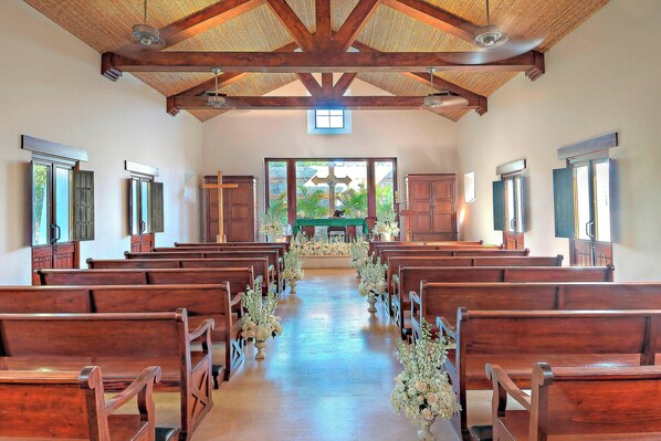 A church interior with wooden pews, a central aisle, and a cross at the front. - The Buenaventura Golf & Beach Resort Panama, Autograph Collection (El Chiru)