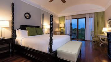 Una habitación de hotel con una cama grande, un escritorio, una silla y un balcón con vistas.