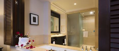 A modern bathroom with a large mirror, a sink, and a shower.