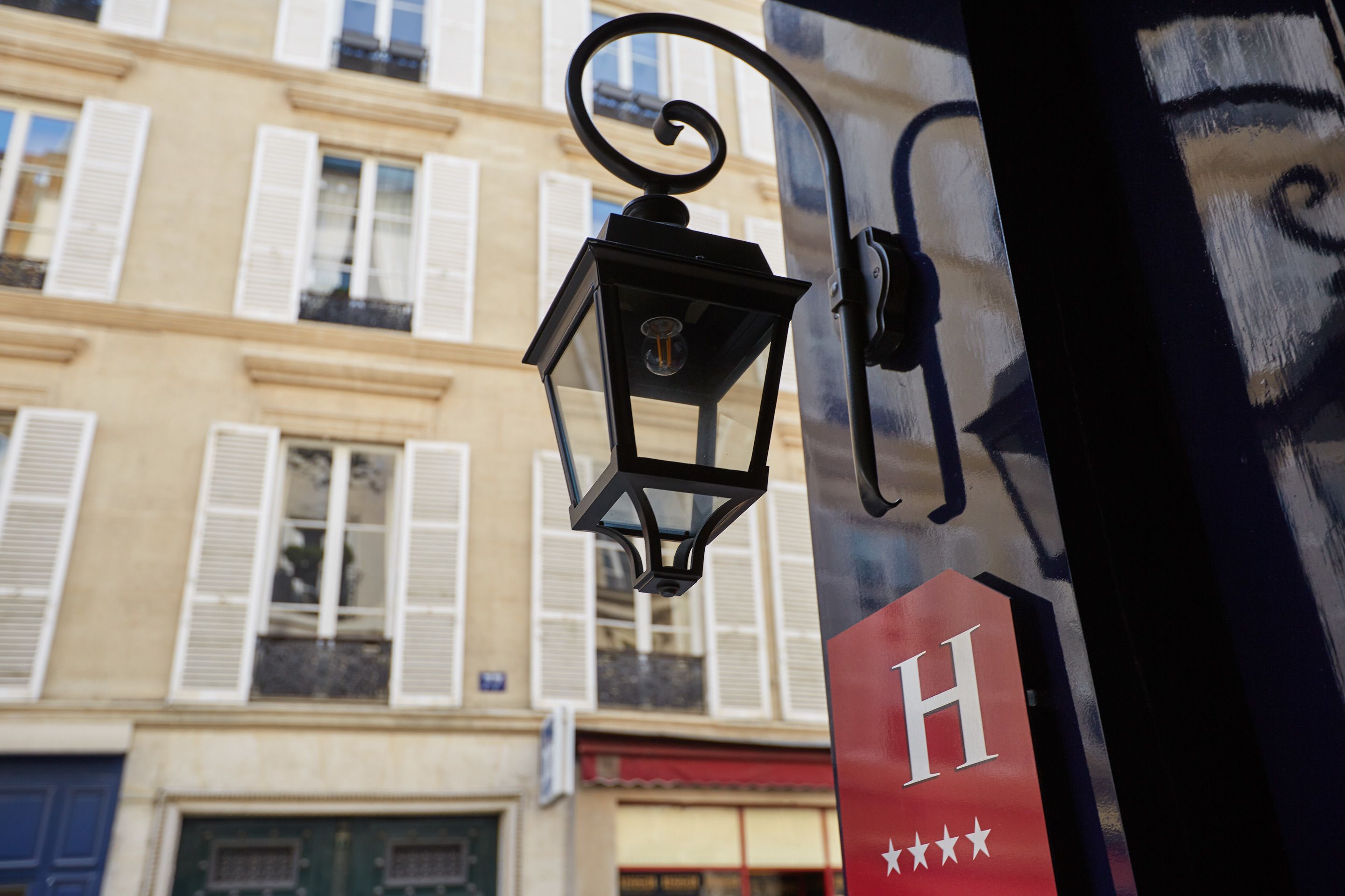 Eine Straßenvorbereitung an einem Gebäude mit einem 'H'-Schild und Sternen, Kennzeichnung als Hotel.